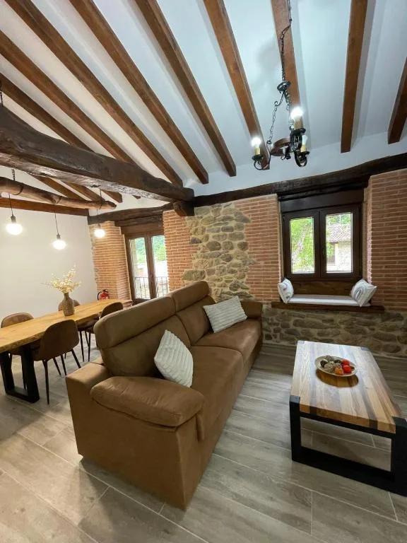 una sala de estar con un sofá y una mesa en Cabaña Los Tejos,
