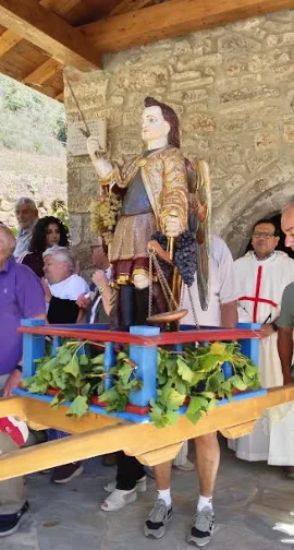 La imagen de San Miguel en andas, engalanada con uvas del valle