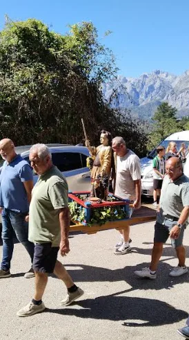 El santo en andas con los Picos de Europa al fondo